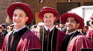 毕业时帽子和礼服的三名男子