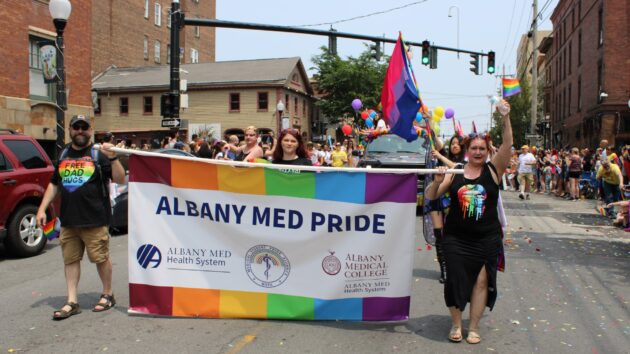 2023年6月的Capital Pride Parade的参与者举行了一个阅读Albany Med Pride的横幅。